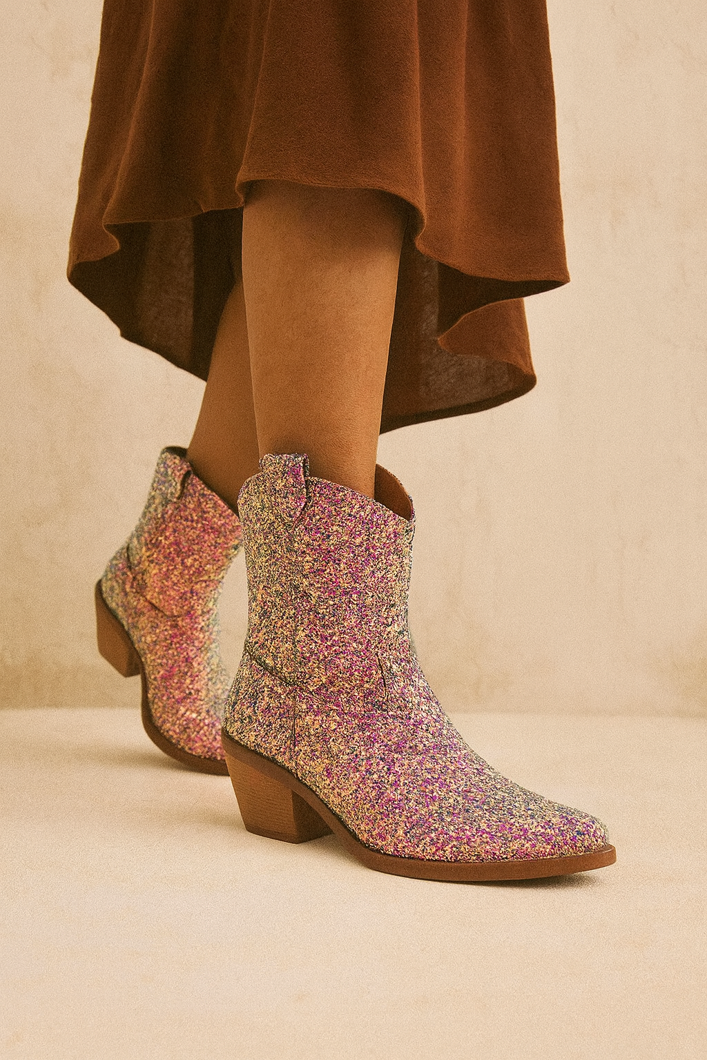 Multicolored patterned boots worn with a brown skirt on a beige background