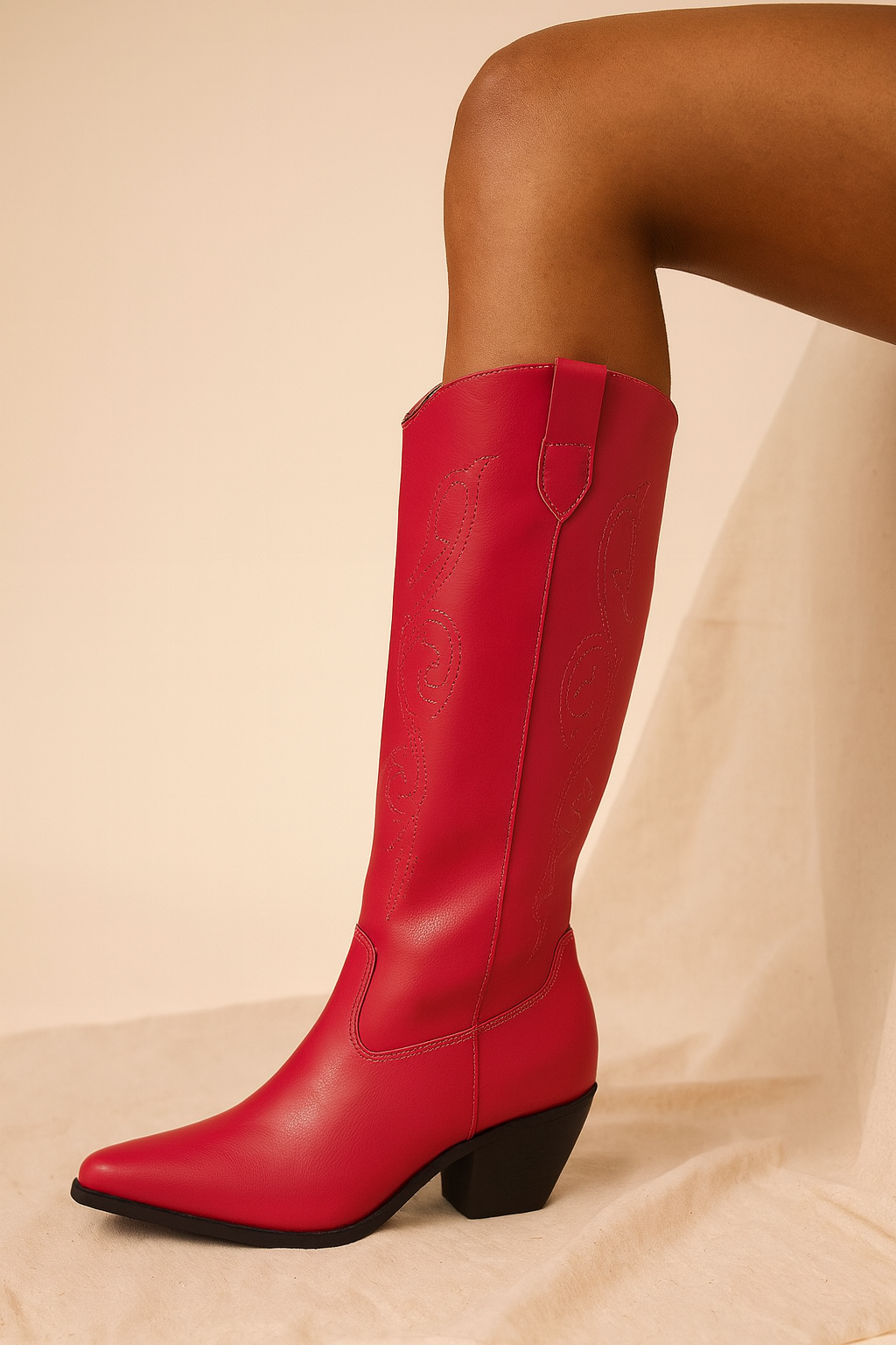 Red knee-high boot on a beige background