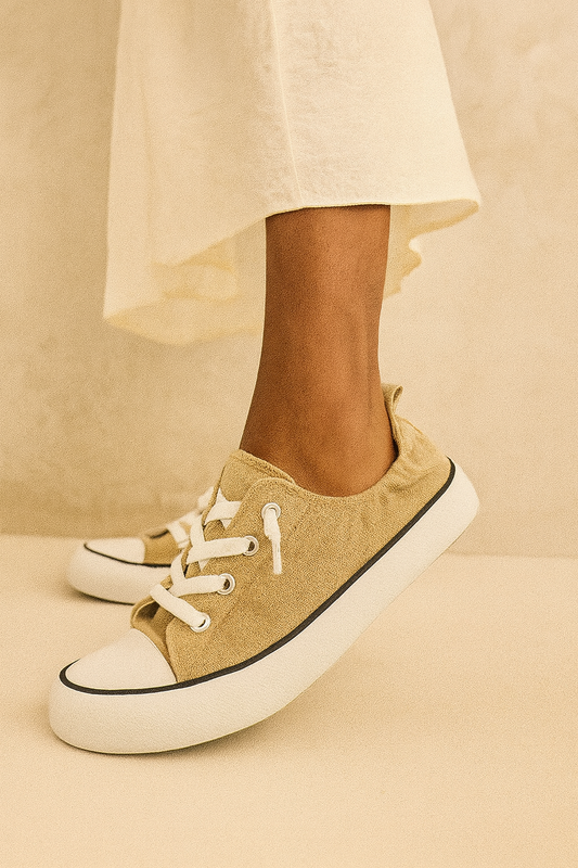 Beige sneakers with white laces on a beige background